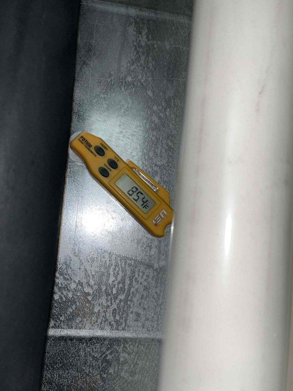 Performed leak search on air handler after unit lost complete refrigerant charge within three days of previous service. Visual inspection revealed significant frost buildup on evaporator coil with surface temperature reading 35.5°F, indicating active refrigerant leak at coil. Interior examination of coil showed accumulated debris and discoloration at central hub area. Diagnosed failed evaporator coil as source of rapid refrigerant loss. Sold and scheduled evaporator coil replacement to restore system operation.