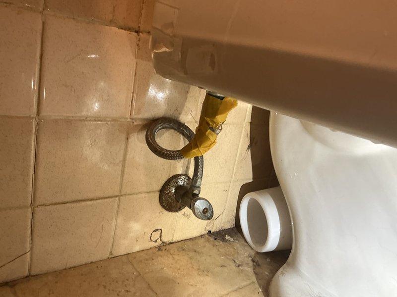 Completed plumbing membership maintenance visit and comprehensive inspection of bathroom fixtures and components. Evaluated toilet water supply line condition, noting braided metal flex line with wall-mounted shut-off valve functioning properly, and assessed floor tile condition around toilet base with visible wear and grout discoloration requiring future attention. Inspected bathtub and sink fixtures including shower assembly, handheld shower unit with wall-mounted holder, and drain assemblies, confirming all components operational with no active leaks detected at time of visit.