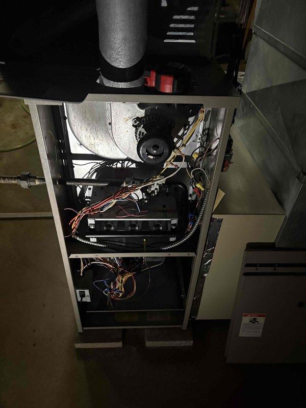 Conducted comprehensive assessment of existing residential HVAC system that was failing to maintain adequate cooling during extreme heat conditions. Evaluated approximately 20-year-old furnace and air conditioning equipment showing signs of age-related performance degradation. Documented current system configuration including furnace cabinet with blower motor assembly, control board, refrigerant lines, and ductwork connections. Photographed internal components revealing organized wiring harnesses, electrical controls, and mechanical assemblies to support replacement estimate documentation. System inspection confirmed equipment was no longer capable of meeting cooling demands, necessitating full HVAC replacement recommendation.