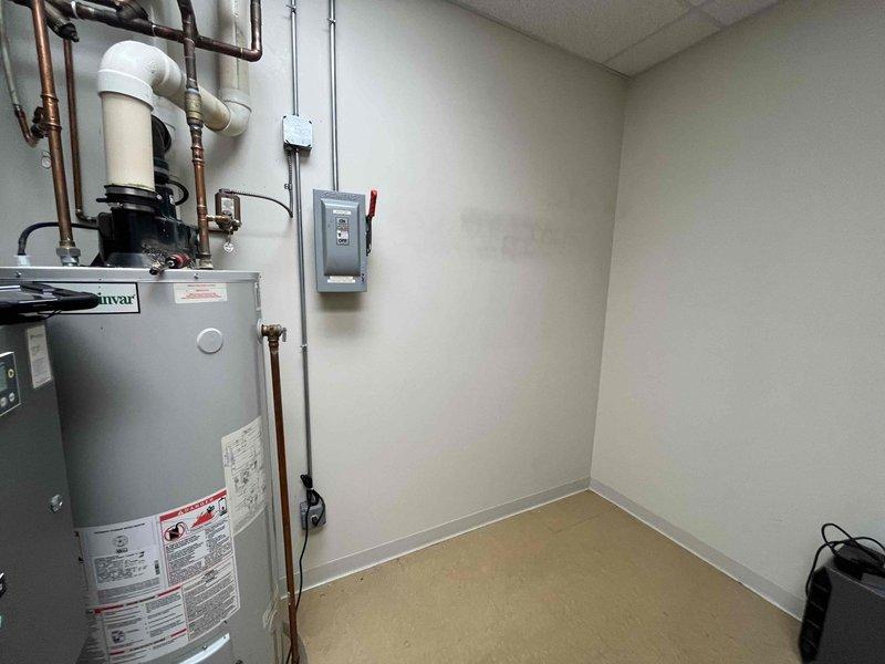 Conducted on-site assessment of existing gas-fired water heater system to develop replacement quote. Evaluated current Ruud tank-type water heater installation, documenting unit specifications including fuel type, venting configuration, and capacity requirements. Inspected power-vented combustion system with PVC vent piping, copper supply and distribution lines, expansion tank, electrical disconnect with safety lockout, and associated plumbing connections to determine replacement specifications and scope of work for future installation.