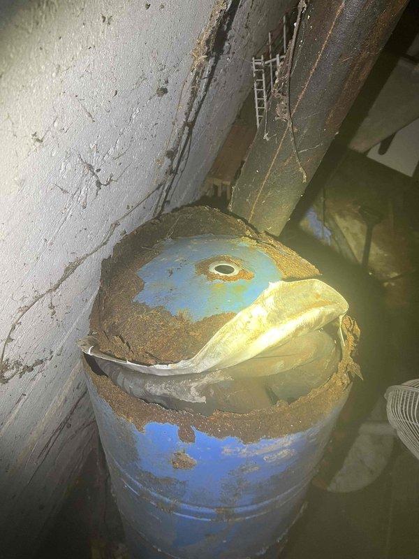 Responded to water emergency at rental property where pressure tank catastrophically failed, rupturing at the bottom and causing significant basement flooding. Upon arrival, found several inches of standing water throughout utility area with pressure tank showing severe corrosion and complete structural failure at base. Well pump system components were partially submerged in flood water. Documented extensive water damage to walls, floor, and surrounding infrastructure. Assessed condition of well pump and associated plumbing connections for water damage and functionality. Photographed failed pressure tank showing advanced deterioration, rust, and corrosion that led to catastrophic failure. Captured documentation of flooded conditions, submerged mechanical equipment including brass fittings and flexible conduit, and water intrusion affecting electrical panel area. Provided photographic evidence and detailed findings for property management review regarding necessary repairs and equipment