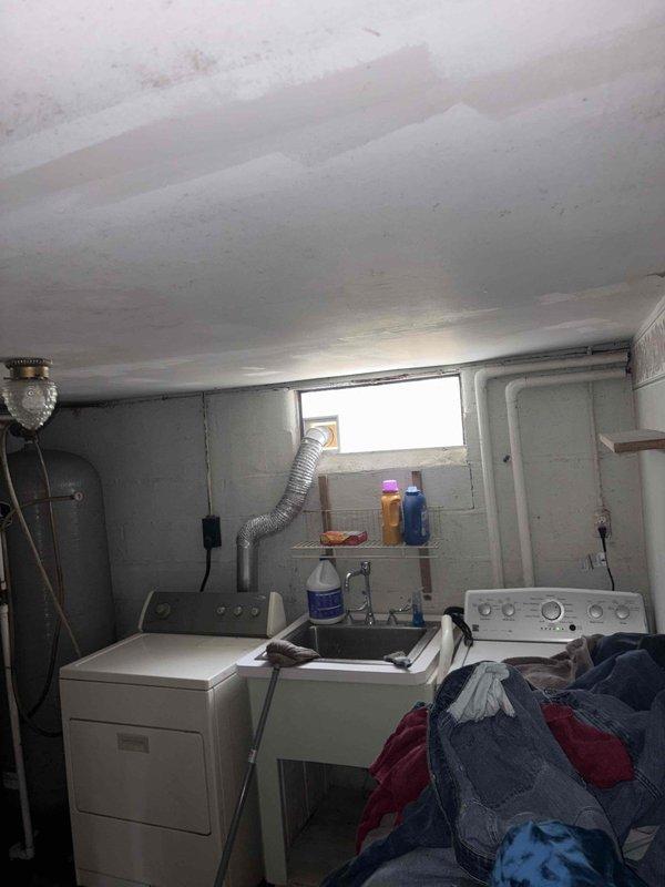 Performed assessment of existing boiler system in residential basement following homeowner concerns about inadequate heating capacity after home addition was completed. Evaluated boiler sizing relative to current heating load requirements, documented existing equipment configuration including water heater and distribution piping, and photographed mechanical room layout to support replacement estimate for properly sized heating system.