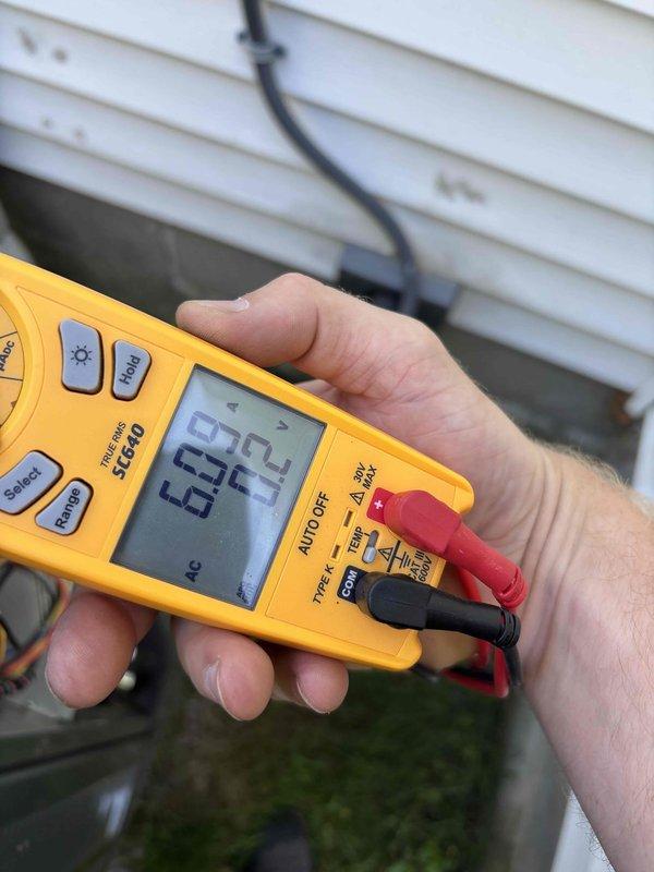 Completed HVAC club membership renewal service visit. Performed system diagnostics and electrical measurements on outdoor unit, recording voltage readings of 6.02V and 45.4V using calibrated digital multimeter to verify proper electrical supply and component operation. Unit operational and meeting manufacturer specifications at time of inspection.