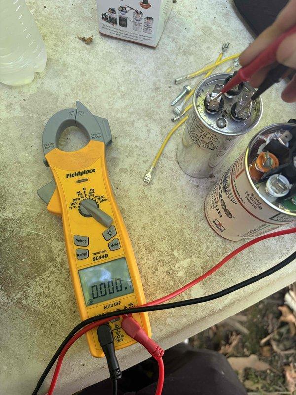 Responded to no cooling call on 2008 Trane air conditioning system. Upon arrival, performed diagnostic testing on outdoor unit using clamp meter and found failed dual-run capacitor with zero amperage reading to compressor. Replaced defective capacitor with new dual-run unit, verified proper electrical connections, and confirmed compressor amperage at 36.79A within manufacturer specifications. System tested and restored to normal cooling operation.