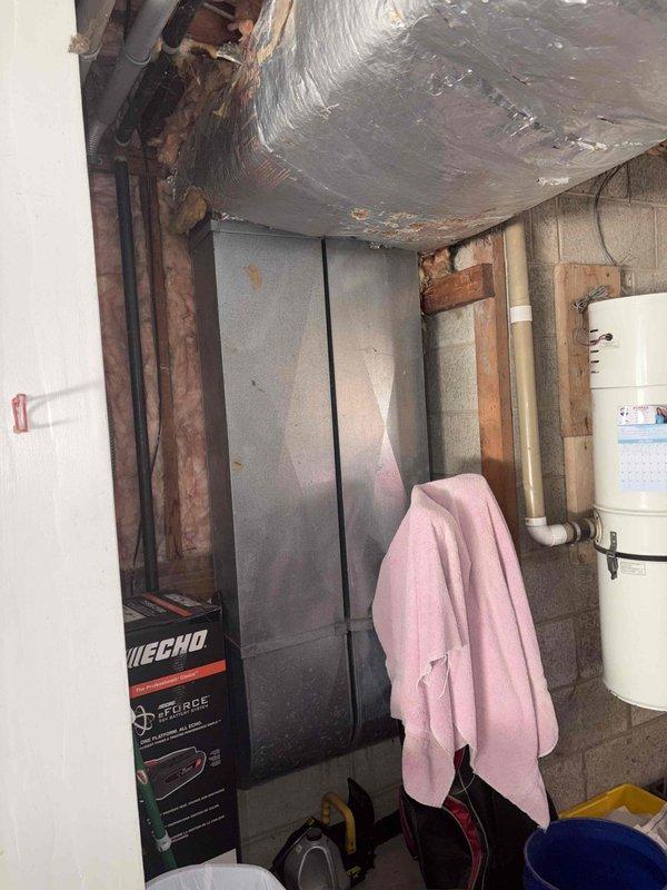 Responded to no cooling complaint on residential property with 2008 Trane air conditioning system. Upon arrival, evaluated 18-year-old outdoor condensing unit and indoor air handler located in basement mechanical room. Conducted comprehensive system assessment including electrical connections, refrigerant circuit components, and ductwork configuration. Due to age of equipment and nature of failure, provided detailed estimate for complete HVAC system replacement. Documented existing installation with photos showing current air handler placement on concrete block stand, existing flexible ductwork connections with reflective insulation, electrical disconnect and wiring configuration, and overall mechanical room layout for proper equipment sizing and replacement planning.