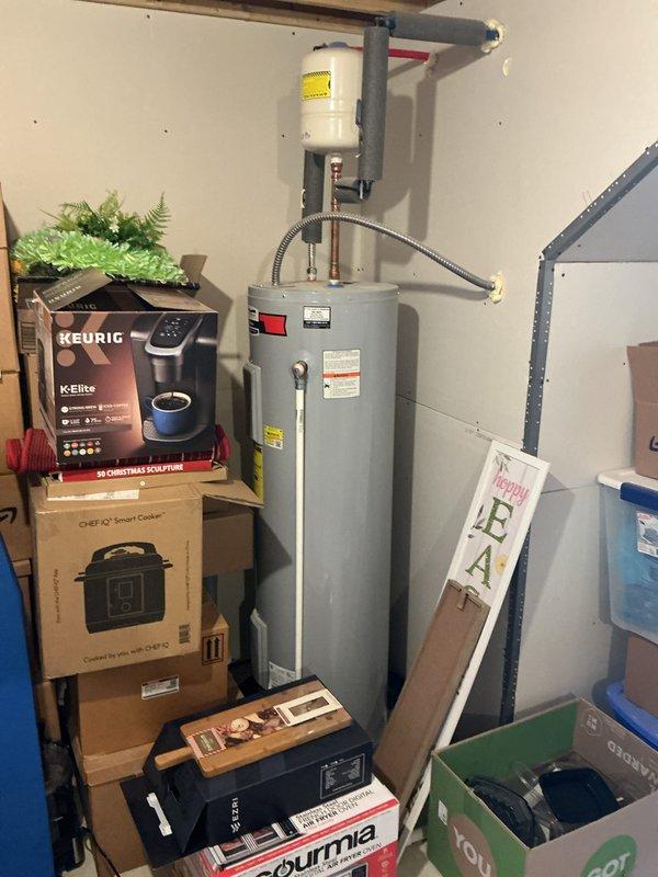 Completed routine plumbing membership inspection at residential property. Examined bathroom shower arm and wall flange installation for proper mounting and potential leaks, and inspected water heater unit in storage closet, checking copper supply lines, insulated piping connections, and safety shutoff valve operation to ensure system is functioning within normal parameters.