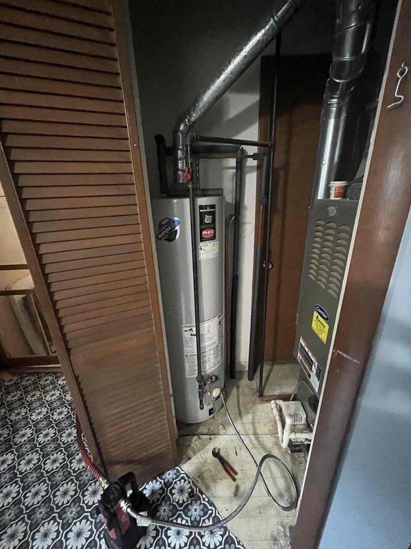 Responded to emergency service call for water pooling on garage floor in residence built circa 1950. Upon arrival, inspected tanked water heater and surrounding utility closet area containing HVAC equipment. Conducted thorough visual assessment of water heater unit, including examination of tank exterior, piping connections, valve assemblies, and copper supply lines for signs of leakage or failure. Photographed equipment and mechanical room conditions for documentation purposes. Evaluated age and condition of existing water heating system in relation to reported water accumulation issue.