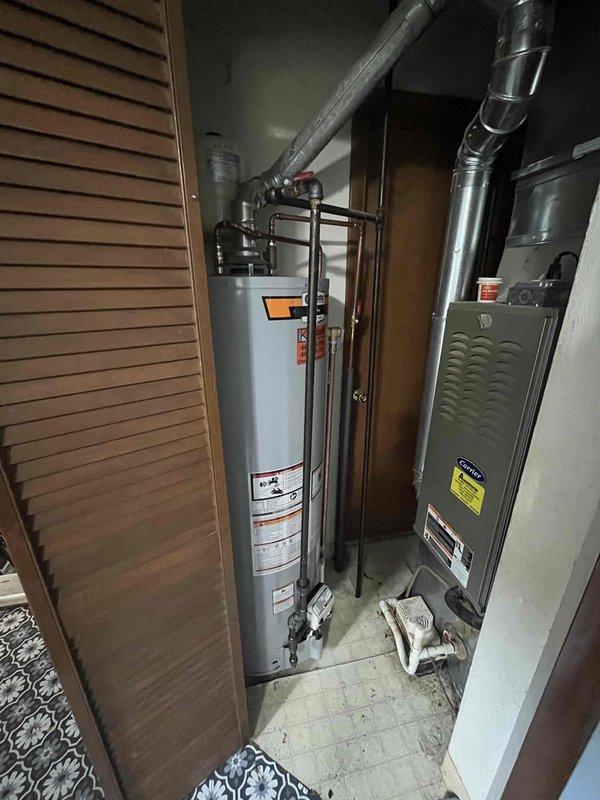 Responded to emergency service call for water pooling on garage floor in residence built circa 1950. Upon arrival, inspected tanked water heater and surrounding utility closet area containing HVAC equipment. Conducted thorough visual assessment of water heater unit, including examination of tank exterior, piping connections, valve assemblies, and copper supply lines for signs of leakage or failure. Photographed equipment and mechanical room conditions for documentation purposes. Evaluated age and condition of existing water heating system in relation to reported water accumulation issue.