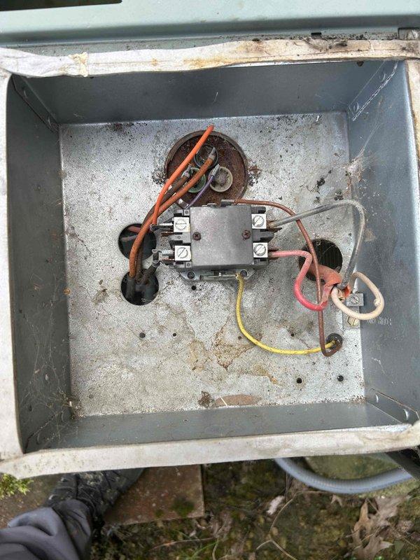 # Emergency No Cooling Call - 25-Year-Old System

Responded to emergency service call for complete loss of cooling on residential air conditioning unit approximately 25 years old. Upon arrival, performed visual inspection of outdoor condensing unit and electrical components. Opened electrical junction box to assess wiring connections and capacitor condition. Found system with significant age-related wear, corrosion on electrical enclosure, and accumulated dirt and debris throughout cabinet and electrical compartment. Documented equipment condition with photographs showing weathered components, rust staining on junction box interior, and general deterioration consistent with unit age. Inspected capacitor, contactor assembly, and wire connections for signs of failure. Evaluated overall system condition and serviceability given advanced age of equipment. Provided assessment and recommendations to customer regarding repair versus replacement options for aging unit that has exceeded typical