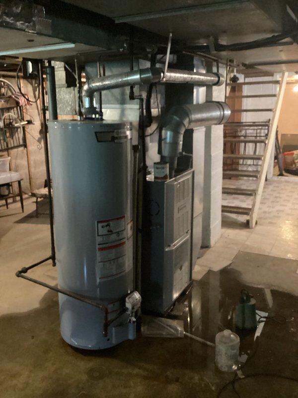 Responded to furnace replacement inquiry due to significant water leakage observed in basement mechanical room. Assessed existing furnace and water heater system, documented moisture damage on concrete floor surrounding equipment, and provided customer with replacement options for leaking furnace unit.