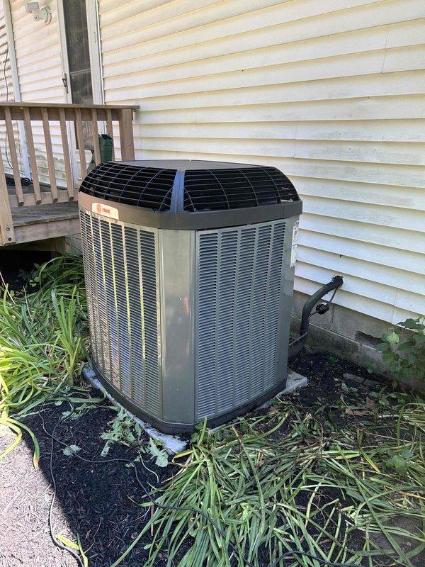 Responded to service call for residential air conditioning system. Upon arrival, performed diagnostic evaluation of outdoor condensing unit and indoor air handler system. Utilized digital temperature measurement equipment to assess system performance and verify operating conditions. Found system operating with low refrigerant charge affecting cooling capacity. Added refrigerant to manufacturer specifications and verified proper system pressures and temperatures. Confirmed adequate airflow through condenser coils despite vegetation growth near unit perimeter. System tested and operating within normal parameters upon completion. Customer also requested separate estimate for downspout cleaning at air handler location.