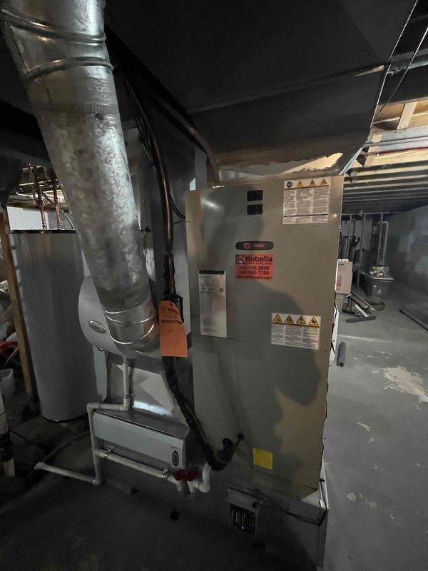 Completed cooling maintenance club visit on residential HVAC system. Performed electrical diagnostics using digital multimeter to verify proper voltage and amperage readings on system components. Inspected Kobella furnace/air handler unit in basement mechanical room, checking all warning labels, specifications, and operational components. Evaluated ductwork condition and assessed overall system performance to ensure optimal operation for the cooling season.