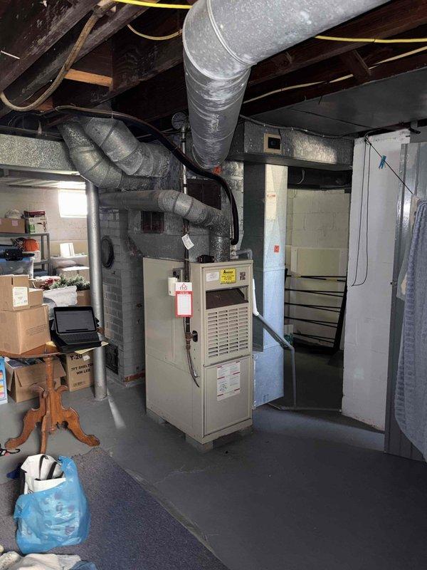 Performed comprehensive evaluation of aging HVAC system exceeding five years of service life to assess replacement needs. Completed full air conditioning tuneup including inspection of electrical components, circuit breaker panel with dedicated 30-amp AC circuits, and basement-installed furnace unit with associated ductwork and ventilation systems. Documented existing equipment condition through photographic records showing current electrical infrastructure, furnace installation with flexible and rigid ductwork configuration, and overall system layout to support replacement estimate recommendations.