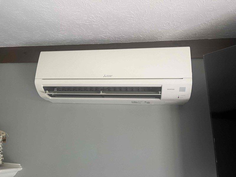 Responded to service call for leaking 10-year-old Mitsubishi Electric ductless mini-split air conditioning unit. Upon arrival, performed visual inspection of wall-mounted indoor unit and surrounding area. Conducted moisture measurement testing using digital meter, which indicated elevated moisture level of 54% at the unit location. Inspected drain line system, condensate pan, and refrigerant connections for source of water leak. Documented equipment condition and moisture readings with photos for service records.