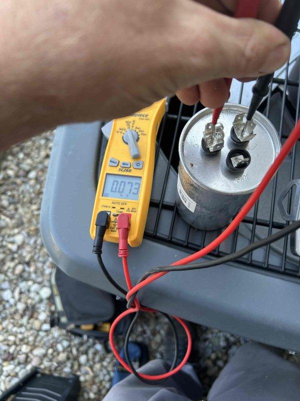 Responded to no cooling call on Amana condensing unit installed in 2020. Upon arrival, performed electrical diagnostics using multimeter to test capacitor functionality. Measured voltage and capacitance values on the dual run capacitor, which showed failed readings of 00.05, indicating capacitor failure. Replaced defective capacitor with properly rated replacement component, verified all electrical connections, and confirmed system returned to normal cooling operation with proper compressor and fan motor function.