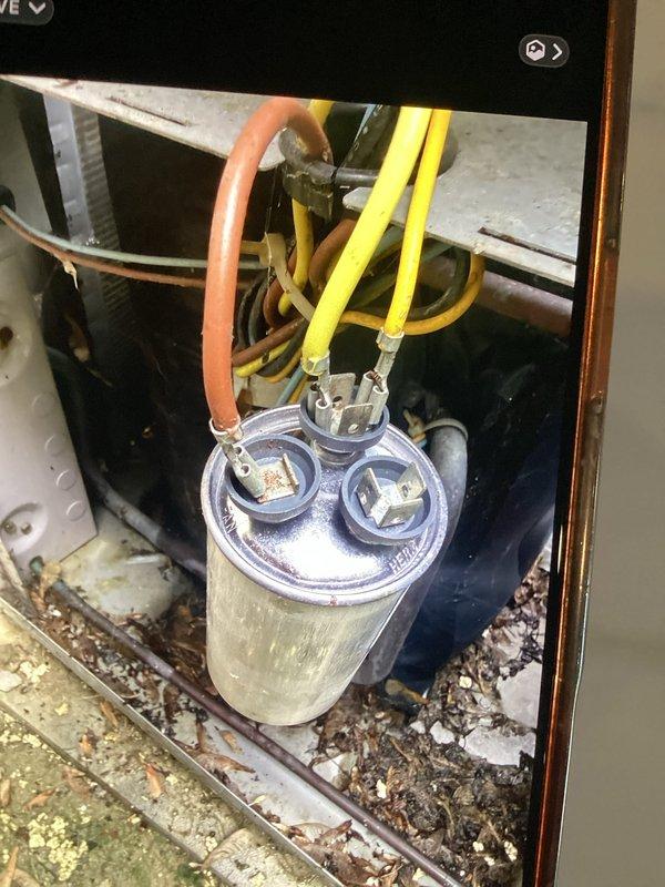 Responded to no cooling call on air conditioning unit less than 10 years old. Upon arrival, found capacitor had failed, preventing compressor from starting despite thermostat displaying properly. Tested capacitor with multimeter, confirming readings outside acceptable range. Replaced defective dual run capacitor, cleaned debris accumulation from unit base, and verified system operation. Unit restored to normal cooling function with proper amperage draw and voltage readings confirmed.
