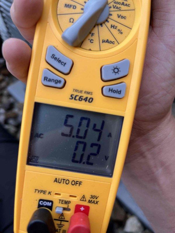Completed cooling maintenance club visit on air handler system. Performed electrical diagnostics using clamp meter, recording amperage draw of 5.04 amps and voltage reading of 0.2 volts during system operation. Calculated and verified electrical performance parameters to ensure system operating within manufacturer specifications. All measurements documented photographically for service records. System operating properly upon completion of maintenance visit.