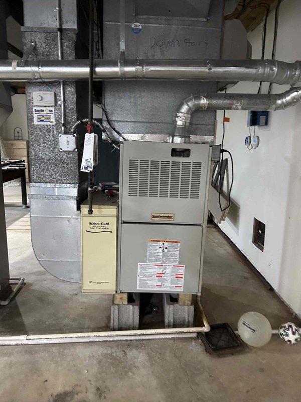 Responded to no cooling call following power surge with clicking sounds reported at air handler. Upon inspection, found furnace and air handler system in basement with electronic control board and zone control system. Evaluated electrical components, control boards, and thermostat wiring for surge damage; verified system safety and proper operation of all HVAC controls and zone dampers before restoring unit to service.