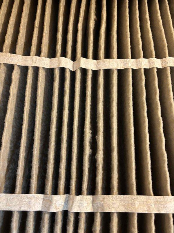 Completed cooling maintenance club visit on air handler system. Performed system diagnostics using digital multimeter, recording voltage reading of 198.8V to verify proper electrical supply to unit. Inspected and evaluated air filter condition, noting moderate to heavy dust and particulate accumulation throughout pleated media, with significant darkening visible in lower sections indicating reduced airflow efficiency. Filter replacement recommended during this preventive maintenance visit to maintain optimal system performance and indoor air quality.