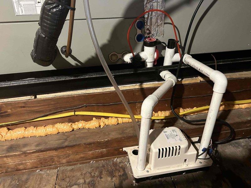 Completed final prepaid cooling maintenance visit on air handler system. Inspected attic-mounted condensate pump assembly, verified proper operation of drainage system including PVC piping and trap configuration, and checked refrigerant line insulation. Confirmed all mechanical components functioning within normal parameters and documented equipment condition with thermal readings.