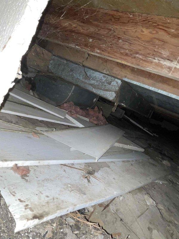 Responded to complaint of sewage odor in 70-year-old residential property. Performed inspection of crawlspace and structural areas to identify source of sewer gas infiltration. Investigation revealed deteriorated building materials, compromised foundation components, and damaged drywall panels in crawlspace area with visible signs of long-term moisture exposure and structural failure. Documented extensive water damage, rust staining on concrete surfaces, and displaced insulation materials. Identified exposed plumbing components including cylindrical pipe section within compromised structural space. Assessment indicated potential sewer line integrity issues, failed vapor barriers, and inadequate ventilation in crawlspace contributing to sewage smell penetration into living areas. Photographic documentation completed showing deteriorated wooden beams, collapsed ceiling panels, and compromised building envelope. Recommended comprehensive sewer line camera inspection to assess underground 