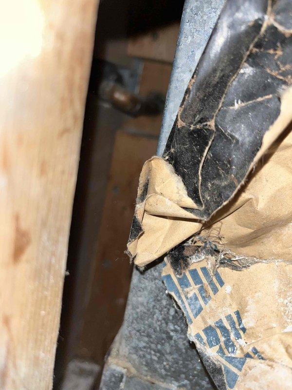 Responded to basement water leak originating from sink drain line concealed within wall cavity. Upon inspection, identified active leak requiring access through drywall or wall material for proper repair. Assessed plumbing infrastructure in basement area, including water heater connections and supply lines. Documented existing conditions with photographs showing utility area layout, exposed piping, and affected wall section. Provided assessment and recommendations for wall penetration to access and repair compromised drain line.