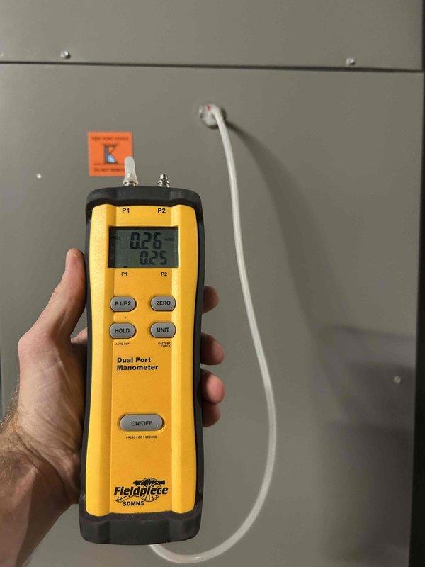 Responded to service call for AC unit causing excessive vibration throughout residence during startup. Upon inspection, measured gas pressure at manifold using digital manometer, recording readings of 0.26 and 0.5 inches water column at dual ports. Verified gas supply valve operation and inspected associated piping connections to HVAC equipment. Documented equipment conditions and pressure measurements to determine cause of vibration issue during compressor engagement.