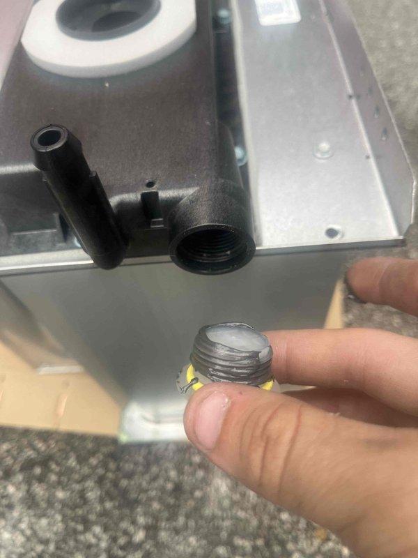 Returned to property for warranty heat exchanger replacement that was previously sold and approved. Confirmed material has been ordered and verified that approximately 8 hours of labor will be required once the replacement heat exchanger arrives on site. Accessed furnace cabinet and documented current condition of existing heat exchanger and blower assembly. Inspected motor assembly, blower housing, and associated electrical connections in preparation for upcoming replacement work. Photographed internal components including the cylindrical blower motor with mounting hardware, white plastic housing sections, and wiring connections. Examined threaded gas connections and fittings that will need to be disconnected during heat exchanger removal. Scheduled potential installation date to ensure adequate time allocation for complete heat exchanger replacement procedure. Unit remains operational pending arrival of warranty replacement part.