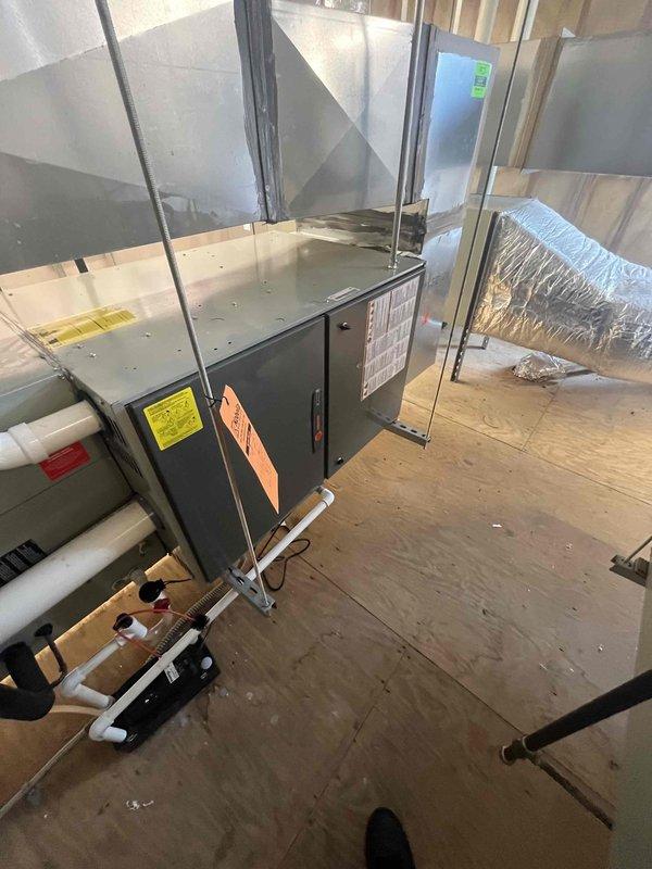 Responded to service call for non-operational cooling system in commercial intake room. Upon inspection, assessed existing HVAC unit and ductwork configuration in mechanical space. Documented equipment conditions and system layout, including gray metal air handler unit, metallic flexible ductwork, rigid metal supply/return ducts, and associated PVC drainage piping. Provided comprehensive estimate for complete system replacement to restore cooling capacity to the intake room area.