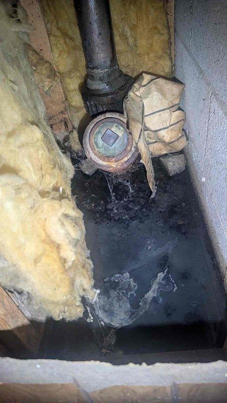 Responded to water leak in basement bathroom with saturated walls and floors. Upon investigation, accessed crawl space and attic areas to identify source of leak. Inspected plumbing components including corroded cast iron drain pipe and fittings showing significant rust and oxidation. Documented deteriorated fiberglass insulation compressed from water exposure. Assessed drainage system connections and flexible ductwork in ceiling cavity. Photographed damaged areas including compromised pipe fittings with visible corrosion and water-stained surfaces for documentation purposes.