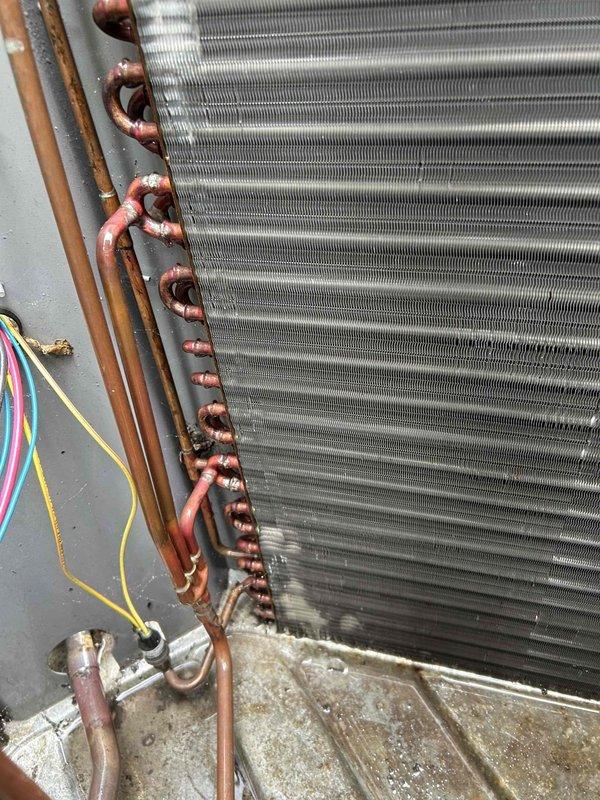 Completed routine cooling maintenance member visit on HVAC system. Performed comprehensive inspection of heat exchanger coil assembly, verifying fin condition and refrigerant line connections. Documented system components with photos showing evaporator coil with aluminum fins and copper U-bend refrigerant distribution lines, noting normal patina on copper tubing consistent with system age. Conducted electrical diagnostics using clamp meter, measuring system amperage at 15.14 amps, which falls within normal operating parameters. Inspected all electrical connections and wiring harness to control board. System operating properly with no issues identified during this scheduled maintenance visit.