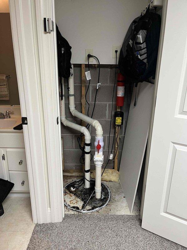 Responded to sump pump alarm activation in utility closet. Upon inspection, found sump pump system with basin installed in concrete floor with PVC discharge piping and check valve assembly. Verified pump operation, tested float switch mechanism, and confirmed proper electrical connections. Cleared debris from basin and ensured adequate drainage. System returned to normal operation with alarm silenced and pump cycling correctly.