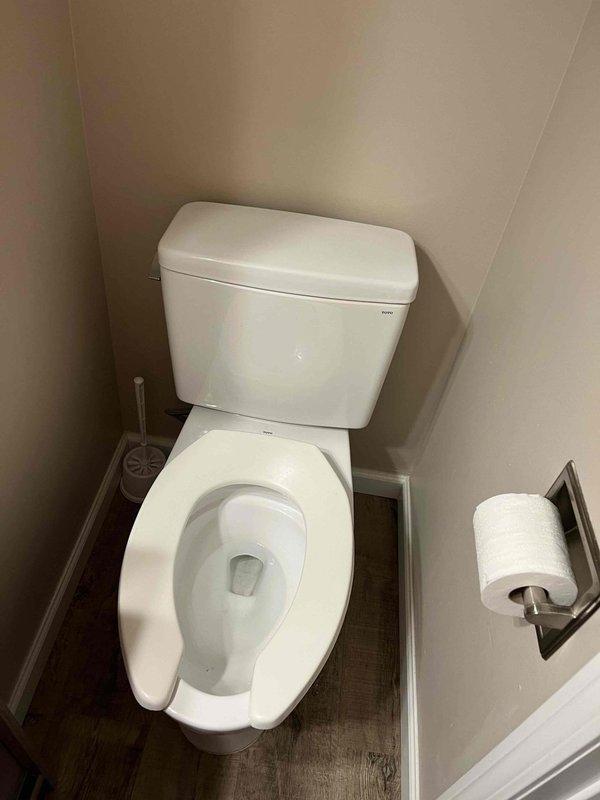 Responded to emergency call for active water leak flooding through ceiling with source identified at toilet. Upon arrival, located and shut off water supply to stop flooding. Inspected toilet assembly and surrounding plumbing connections in bathroom. Assessed water damage extent and verified leak source was isolated. Documented mechanical room equipment and bathroom fixture conditions. Completed emergency service to stop active flooding and prevent further water damage to structure.