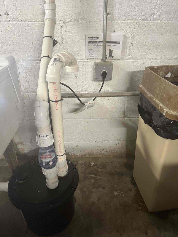 Completed comprehensive sump pump inspection and service on existing Zoeller M53 sewage pump system originally installed in 2012. Verified pump operation, checked discharge piping and check valve functionality, tested float switch mechanism, and inspected electrical connections and control box. Updated service documentation on discharge pipe with current inspection date for maintenance tracking purposes.