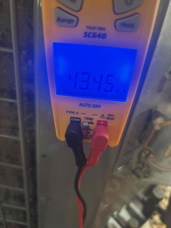 # HVAC Service Report

## Customer Complaint
Customer reported air conditioning system not producing cold air, outdoor fan not operating, and whistling noise occurring shortly after unit startup. Issue affected cooling throughout entire home.

## Diagnostic Findings
Responded to no-cool complaint on residential air conditioning system. Upon arrival, confirmed outdoor condensing unit fan motor was inoperative. Performed visual inspection of outdoor unit components and identified failed run capacitor as primary issue.

## Testing and Measurements
Used digital multimeter to test capacitor functionality. Capacitor tested outside acceptable microfarad range, confirming component failure. Verified voltage supply to unit was within normal operating parameters at standard residential service voltage. Capacitor failure explained both the inoperative condenser fan motor and subsequent whistling noise, which was caused by compressor attempting to operate without proper fan motor operation and air