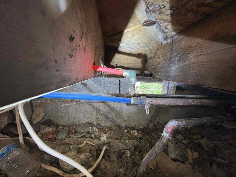 Responded to urgent plumbing service call to complete repairs previously started by another licensed plumber based on Elite Safety inspection findings. Accessed crawlspace area to assess existing plumbing installation and identify remaining issues requiring completion. Inspected PEX water supply lines (blue and red) running through floor joists, including connection points, fittings, and support brackets. Examined copper piping, flexible hoses, and associated plumbing components in the overhead structural space. Evaluated pipe routing, mounting hardware, and overall installation integrity throughout the crawlspace and attic areas. Documented conditions with photographs and contacted customer to discuss findings and necessary repairs before proceeding with additional work to ensure all plumbing issues identified in the original safety inspection were properly addressed and completed to code.