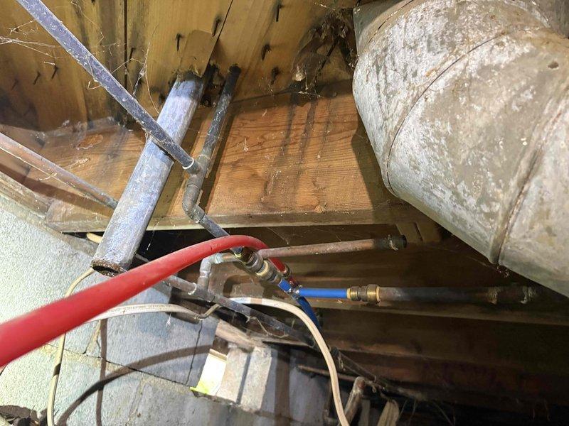 Responded to urgent plumbing service call to complete repairs previously started by another licensed plumber based on Elite Safety inspection findings. Accessed crawlspace area to assess existing plumbing installation and identify remaining issues requiring completion. Inspected PEX water supply lines (blue and red) running through floor joists, including connection points, fittings, and support brackets. Examined copper piping, flexible hoses, and associated plumbing components in the overhead structural space. Evaluated pipe routing, mounting hardware, and overall installation integrity throughout the crawlspace and attic areas. Documented conditions with photographs and contacted customer to discuss findings and necessary repairs before proceeding with additional work to ensure all plumbing issues identified in the original safety inspection were properly addressed and completed to code.