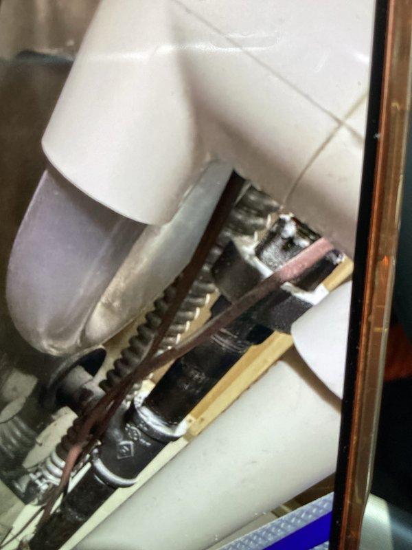 Performed routine cooling maintenance member visit to address reported AC leak at air handler. Inspected condensate drain system and found evidence of moisture accumulation beneath unit, with visible corrosion on drain piping components. Verified proper drainage function and measured system voltage at outdoor condenser unit, recording 65.9 volts during diagnostic testing. Documented plumbing connections and electrical readings with photos for service records.