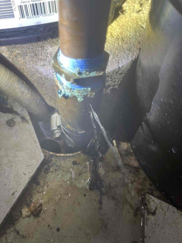 Responded to emergency call for major water leak inside fifty-year-old residence. Upon arrival, identified active leak at water heater connection point with water pooling on concrete floor beneath compromised pipe fitting. Applied temporary blue sealing tape to leaking connection to mitigate immediate water discharge. Inspected complete water heater plumbing assembly including brass manifold connections, pressure relief valve, shutoff valves, and insulated supply lines. Assessed condition of aged brass fittings showing oxidation and verified pressure gauge functionality. Documented existing installation configuration and leak source for repair recommendations. Controlled water flow to prevent further interior damage while evaluating system integrity.