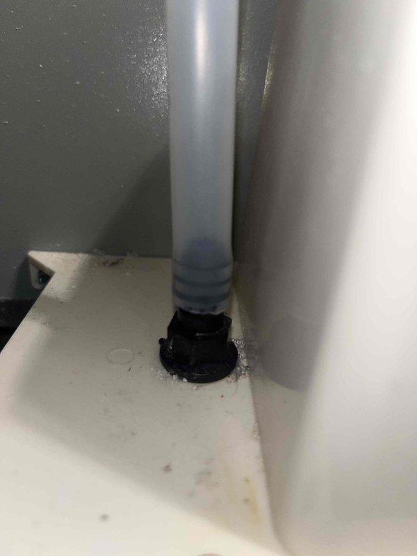 Responded to callback for leaking condensate tubing. Upon arrival, inspected the condensate drain system and confirmed water leakage at the base connection point where the PVC drain line passes through the unit floor. Secured the loose drain fitting and verified proper seal at the black grommet mounting point to eliminate the leak. Tested the condensate drainage system to confirm proper flow and verified no additional moisture present at the connection point.
