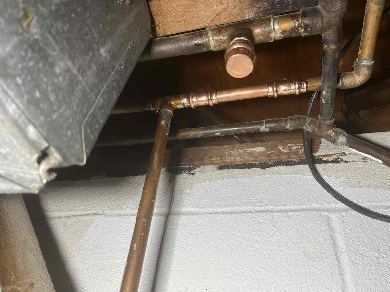 Installed and secured valve assembly as part of larger plumbing system integration. Mounted copper refrigerant lines to metal ductwork using appropriate brackets and hardware, ensuring proper positioning and support of pipes throughout the installation area. Applied spray foam insulation to foundation surfaces to complete thermal envelope requirements for the system.