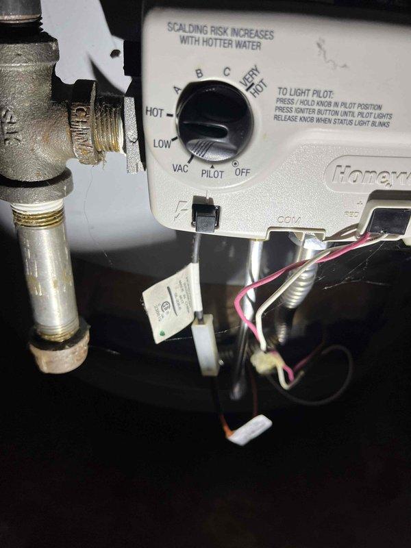 Responded to service call for gas water heater failing to ignite and provide hot water in 30-year-old residence. Upon inspection, accessed the burner assembly and gas control valve system. Examined the Honeywell gas control valve, pilot assembly, and ignition components including the thermocouple and pilot burner. Verified gas supply connections and tested control valve operation through the pilot lighting sequence. Photographed the internal burner chamber showing the pilot assembly and flame sensor positioning, as well as the gas control valve with temperature settings and pilot lighting instructions clearly visible. Assessed the faucet issue as requested by customer. Documented equipment condition and operational status with detailed photographs of critical components for service records.
