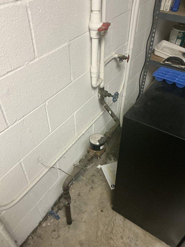Performed commercial backflow prevention testing on PVC and metal piping assembly in utility room. Standard testing procedures completed on accessible backflow devices with red ball valves; vault testing requiring OSHA safety protocols was assessed and priced separately onsite due to confined space entry requirements. Documentation and photographic records captured of existing plumbing infrastructure including water meter connections and valve configurations.