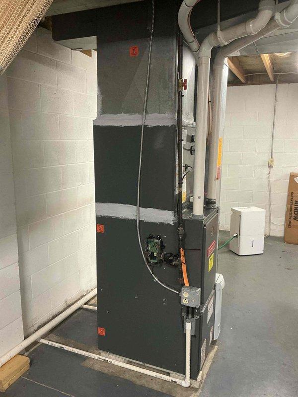 Responded to callback for odor complaint following previous day's air handler installation. Inspected newly installed HVAC system in basement mechanical room, including air handler unit, ductwork connections, and drainage piping. Photographed installation to document equipment placement and verify proper installation of PVC condensate lines, flexible ductwork, and electrical conduit. Confirmed all components were properly secured and connected per manufacturer specifications. System operational with no visible defects or installation issues identified.