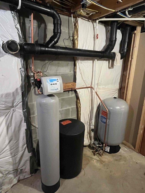 # No Water Service Call

Responded to complete loss of water throughout 27-year-old residential property. Homeowner reported intermittent water supply failure several days prior with temporary restoration, followed by total system shutdown. Upon arrival, conducted comprehensive assessment of basement mechanical room housing water treatment infrastructure.

## Inspection Findings

Inspected dual-tank water treatment system consisting of white softener tank with digital control head and secondary black treatment tank. Evaluated extensive overhead plumbing network with black insulated supply lines and copper distribution piping. Examined gray expansion tank and associated pressure components. Control panel on primary treatment tank displayed operational status indicators.

## Diagnostic Procedures

Tested incoming water supply pressure and flow rates. Verified municipal water service continuity at main shutoff. Assessed water softener regeneration cycle functionality and timer settings. I