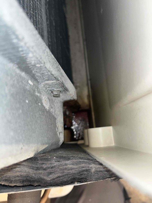 Responded to no heat call on Lennox furnace system. Upon arrival, performed diagnostic inspection of unit located in interior utility closet. Examined manufacturer specification label to determine equipment age and model information. Conducted visual inspection of system components including ductwork connections and cabinet assembly. Noted evidence of deterioration and discoloration at junction where insulated supply duct meets furnace housing, indicating possible historical moisture intrusion or condensation issues. Documented equipment condition and system configuration with photographs for service records. Assessed overall system operation and component integrity to determine cause of heating failure reported from previous winter season.