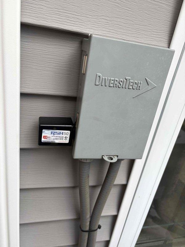 Completed return visit to install two surge protection devices and perform maintenance on HVAC system. Installed DiversiTech weatherproof surge protector enclosure on exterior wall with proper conduit routing and RSH50 secondary protection device. Verified all electrical connections inside furnace cabinet, ensuring proper wire terminations and secure mounting of control components.