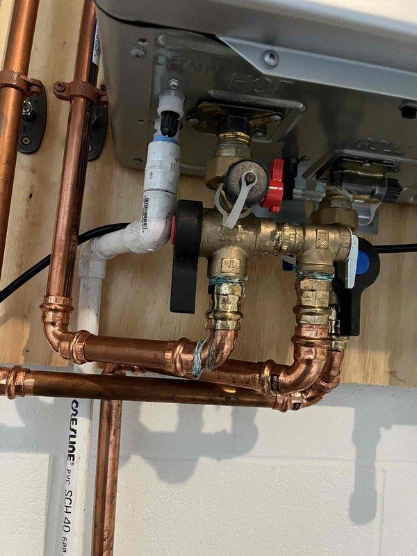 Completed annual maintenance flush on tankless water heater system. Isolated unit using ball valves, circulated descaling solution through heat exchanger to remove mineral buildup, flushed system thoroughly, and restored unit to normal operation. All components including copper piping, brass fittings, and pressure relief valve inspected and found in good working condition with no leaks or issues identified.