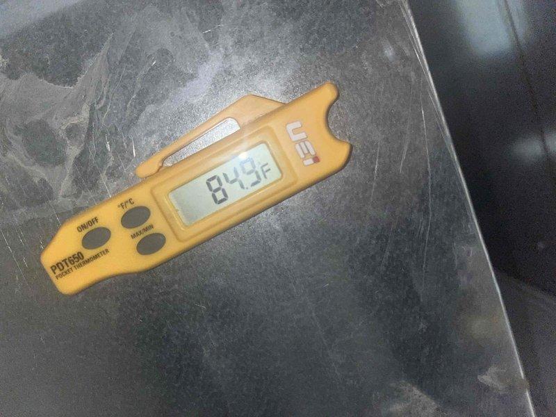 Completed heating maintenance inspection and diagnostics. Observed water staining on wall near PVC condensate drain line indicating potential drainage issues or past overflow events. Verified system temperatures using calibrated digital thermometer, recording 84.3°F reading at equipment location. Documented existing conditions with photographic evidence for maintenance records.