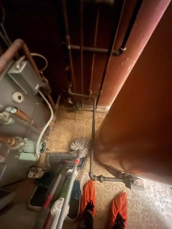 Conducted site evaluation of existing boiler system in basement utility area for potential replacement with wall-mounted unit to accommodate upcoming kitchen remodel. Assessed current installation including expansion tank, copper piping configuration, and mechanical components to determine space requirements and feasibility for either combination boiler or tankless water heater installation. Documented existing equipment layout and mechanical room conditions, noting aged HVAC system components and available clearances for wall-mounted unit placement.